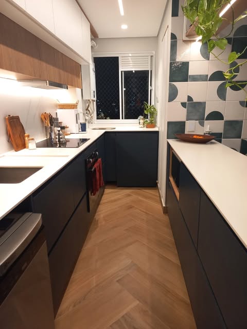 Cozinha em corredor com bancadas claras dos dois lados